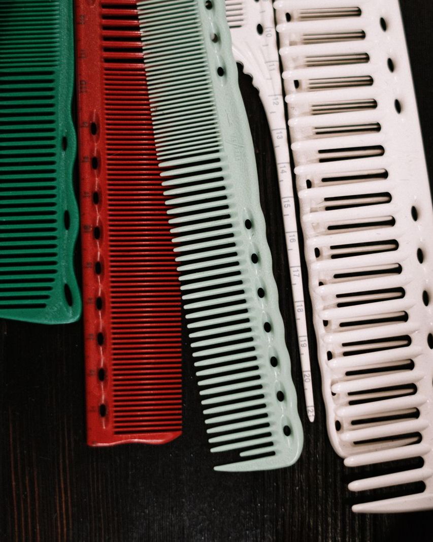 Four cutting combs in green, red, mint and white on a dark counter